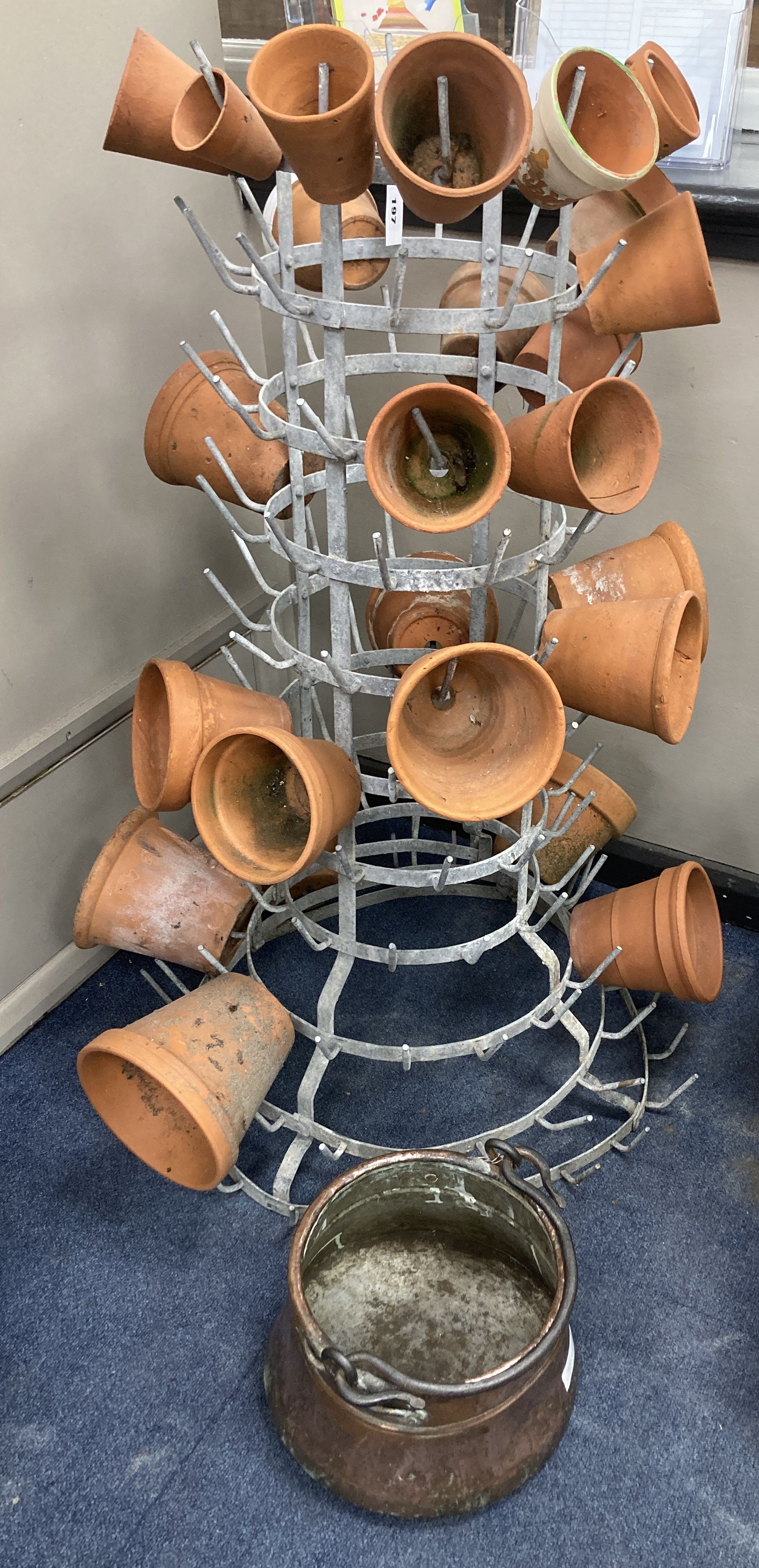 A French metal terracotta pot holder, height 102cm with assorted terracotta pots and an Eastern copper pan, height 21cm